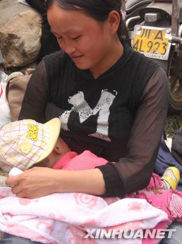 5月16日，汶川县映秀镇的一位妇女在被转移到安全地带后放心地给孩子喂奶