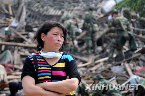 5月16日，四川省什邡市红白镇一位灾民站在成为废墟的家门前
