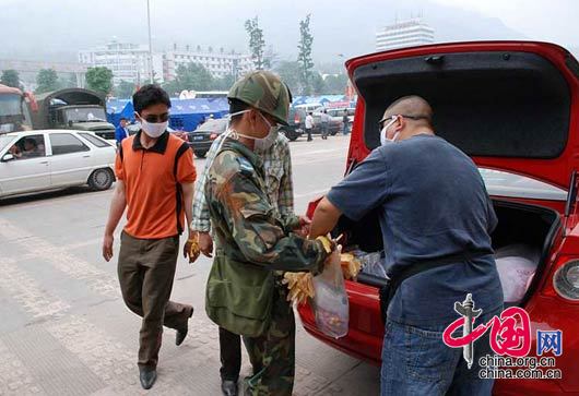 5月17日,橡树摄影网成都志愿队队员将专门购买的1000只口罩，1000双橡皮手套直接送到抢险救灾的士兵手中，他们还送去30件水，10件饼干等。 杨恒/摄影