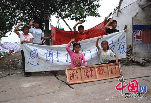 5月17日，綿竹市九龍鎮，災區的孩子們向援助者致意。 楊恒/攝影