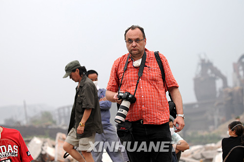 5月16日,一名外国记者在四川省什邡市蓥华镇一处营救现场采访