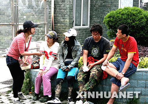 5月17日，韩国留学生在四川省汶川县映秀镇等待直升机运离灾区。