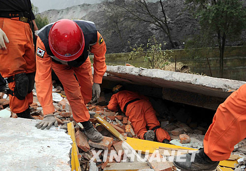 5月17日，韩国救援队队员正在位于什邡市蓥华镇的宏达化工厂进行营救搜寻。