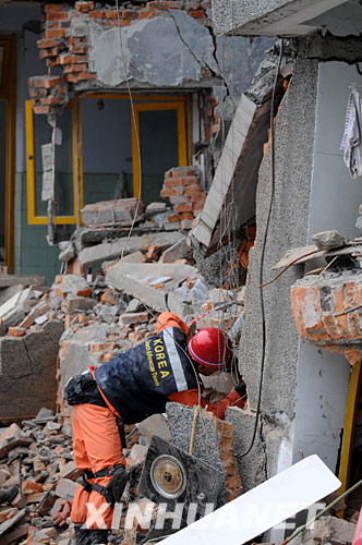 5月17日，韩国救援队的队员在废墟上搜寻幸存者