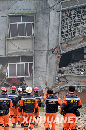 5月17日，韩国救援队的队员在废墟上搜寻幸存者