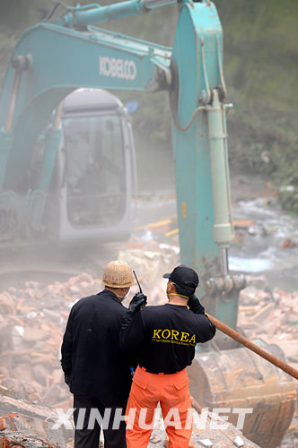 5月17日，韩国救援队的队员在废墟上搜寻幸存者。