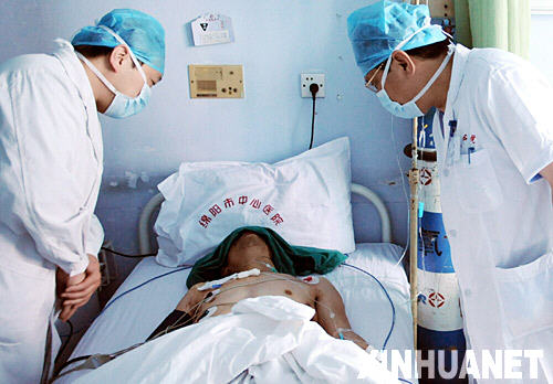 5月18日，两名医生在病房内观察唐雄的身体状况。