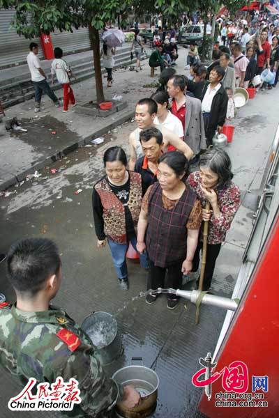 2008年5月14日下午，在都江堰进行抢险工作的消防战士用水车向灾民供水。