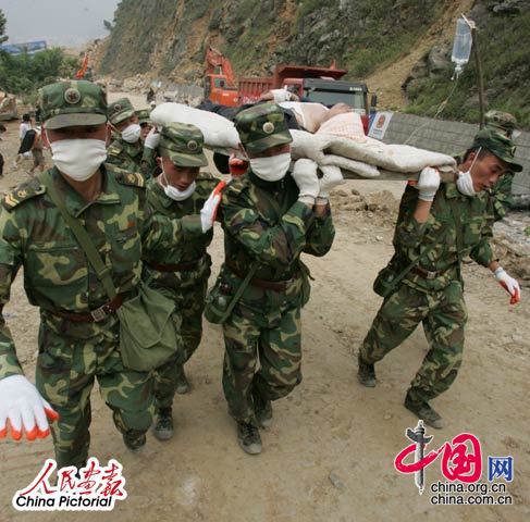 2008年5月16日,四川北川灾区，解放军战士跑步将搜救出的幸存者送往医疗点进行抢救。
