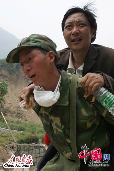 2008年5月16日,四川北川灾区，解放军战士将灾民背送医疗点进行救治。