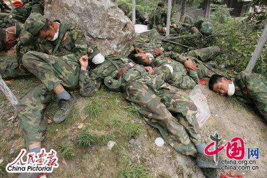 2008年5月16日,四川北川灾区，连日的奋战对参与救援的战士的体力也是一种考验，工作间隙战士躺在路边已进入梦乡。