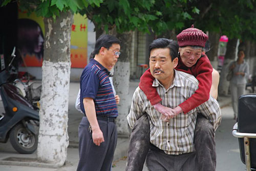 5月12日15点06分：背着邻居76岁老大娘赶往安全地带的青川市民。董开国摄