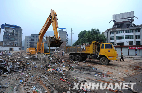 5月25日，施工车辆在清理青川县城区震后废墟。