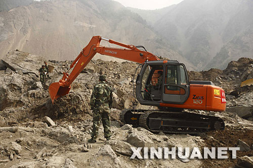 5月26日，武警水電官兵在操作大型機械設(shè)備開辟一條導(dǎo)流槽。當(dāng)日，綿陽唐家山堰塞湖搶險工作全面展開。 新華社記者 才揚 攝 