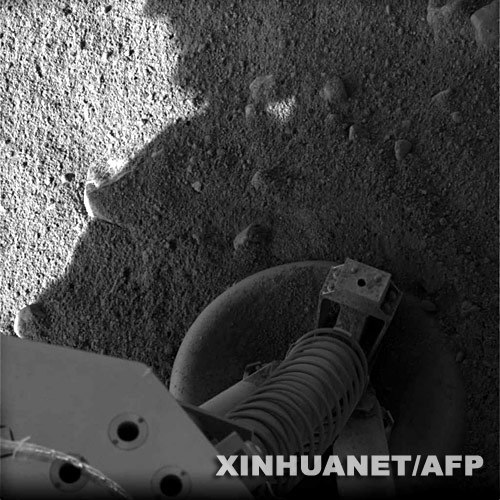 这张5月25日由美国宇航局发布的照片显示的是美国“凤凰”号火星着陆探测器的一条“腿”站立在火星表面。在经历9个多月的太空旅行后，美国“凤凰”号火星着陆探测器25日成功降落在火星北极附近区域，降落2小时后传回第一批图片。 新华社/法新 