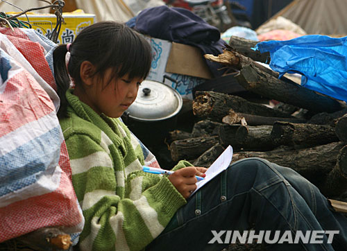 5月26日，在青川县木鱼镇一灾民安置区内，一名小姑娘在学习。