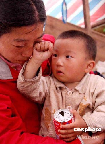 不到两岁的小儿子王光昊似乎看懂了妈妈的悲痛，不停地为妈妈擦拭眼泪。
