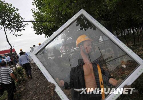 5月29日，在四川省安县黄土镇，人们正在搬运活动板房材料。