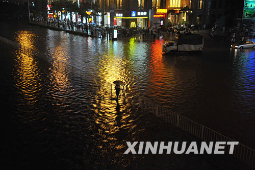 6月2日，一名行人在被雨水浸泡著的街道上行走。 當日，廣州遭遇特大暴雨襲擊，市區多條道路積水嚴重。