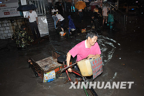 6月2日，一名拉著三輪車的市民在雨水中行走。