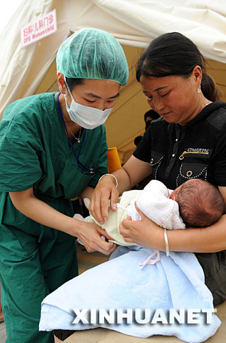 在四川省都江堰市的中德红十字会野战医院，来自上海华山医院的护士刘富菁（左）正在护理一名婴儿