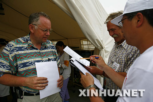 德国红十字会专家嘉德曼（左）在四川省都江堰市的中德红十字会野战医院与同事探讨伤员治疗方案