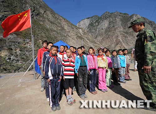 6月10日，濟(jì)南軍區(qū)某裝甲團(tuán)的四川籍大學(xué)生入伍干部王成吉在帶領(lǐng)孩子們進(jìn)行隊(duì)列訓(xùn)練。 6月8日，在濟(jì)南軍區(qū)某裝甲團(tuán)的幫助下，一所帳篷學(xué)校在羌族村寨四川省茂縣石大關(guān)鄉(xiāng)石大關(guān)村建立起來(lái)，老師是部隊(duì)里的大學(xué)生入伍干部和當(dāng)?shù)氐闹驹刚?。連日來(lái)，來(lái)自石大關(guān)鄉(xiāng)及周邊的孩子們陸續(xù)走入帳篷學(xué)校，瑯瑯的讀書(shū)聲使這頂位于岷江岸邊的藍(lán)色帳篷充滿(mǎn)生機(jī)。 新華社記者申宏攝 