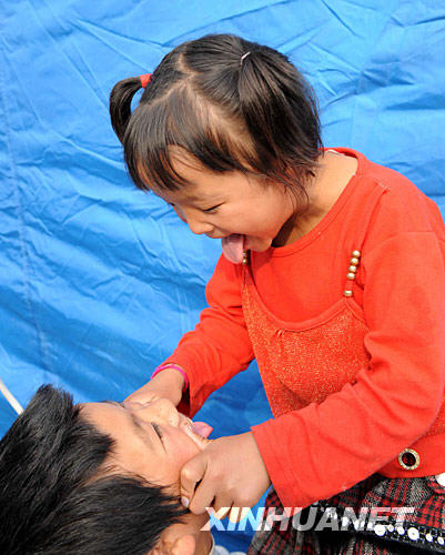 6月10日，阿坝州儿童福利院的7岁女孩王丽和伙伴在帐篷营地里玩耍