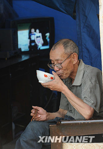 6月10日，阿坝州儿童福利院68岁的肢残老人吕道云在帐篷里吃饭