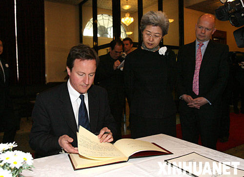 5月20日，在位于伦敦的中国驻英国大使馆，英国保守党领袖卡梅伦（左）在吊唁簿上留言，悼念中国四川汶川大地震遇难者。