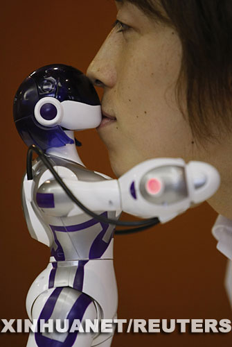 6月16日，日本世嘉玩具公司推出的新型机器人在东京举行的展示活动上亲吻一名男士。这种机器人具有女性的体形，不仅会走路，还会跳舞和与人亲吻。预计从今年9月26日开始在日本国内出售，售价每个1.8万日元（约合166美元） 新华社/路透 
