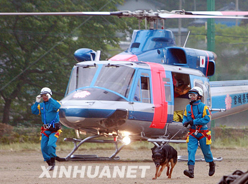  6月16日，两名救援人员携搜救犬乘直升机抵达日本北部地震灾区宫城县栗原市