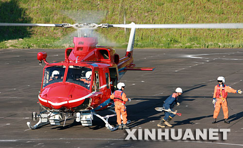 6月15日,在日本北部地震灾区宫城县栗原市,一名救援人员跳下直升机