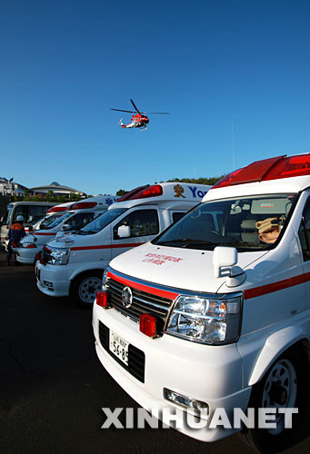 6月15日,在日本北部地震灾区宫城县栗原市,空中的直升机和地面救护车