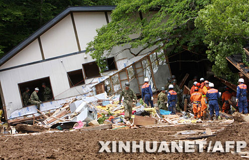 6月15日，救援人员在日本宫城县栗原市一处被地震引发的泥石流冲毁的酒店搜寻幸存者。