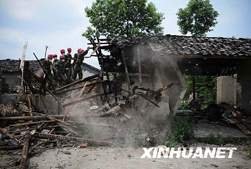 抗震救災官兵幫助綿竹市板橋鎮(zhèn)村民清理危房瞬間（6月19日攝）。