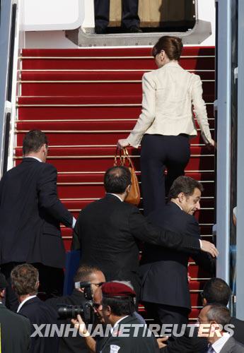 6月24日，在以色列特拉维夫的本－古里安机场，法国总统尼古拉·萨科齐（右，中）和夫人卡拉·布鲁尼（上）在保镖的护卫下冲上总统专机。