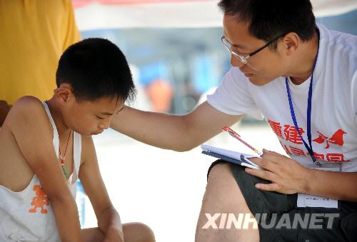 6月26日，中科院心理所专家在抚慰一位在地震中失去父亲的男孩