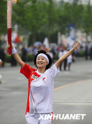 7月19日,火炬手金霞手持火炬進行傳遞.