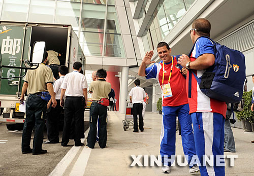  7月27日，剛剛抵達北京首都國際機場的古巴代表團成員向記者揮手致意。當日上午，首批將參加北京奧運會的86名古巴運動員連同官員、工作人員及新聞記者共170余人乘坐古巴航空公司包機抵達北京。 新華社記者陳凱攝 