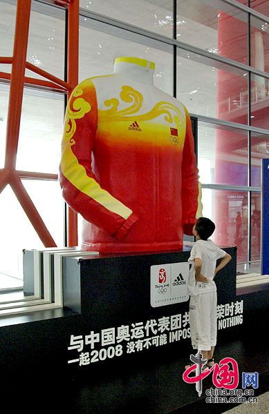 中国奥运军团的服装巨型模型引起不少旅客的浓厚兴趣 龙邦/摄影