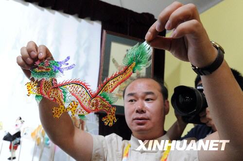 7月28日，北京市皮影艺术剧院的工作人员在奥运村内展示皮影道具。