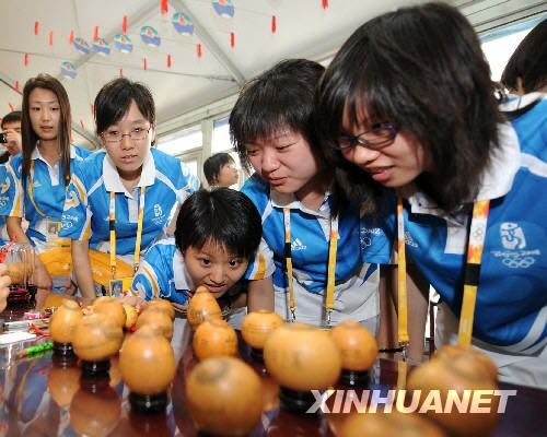 7月28日，奥运村里的志愿者被中国传统手工艺品吸引。