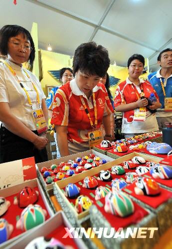 7月28日，北京奥组委奥运村部副部长邓亚萍（前左二）等人在奥运村内欣赏各式京剧脸谱。