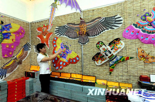 在青岛奥运村中国民俗展的展厅内，一位工作人员在整理风筝