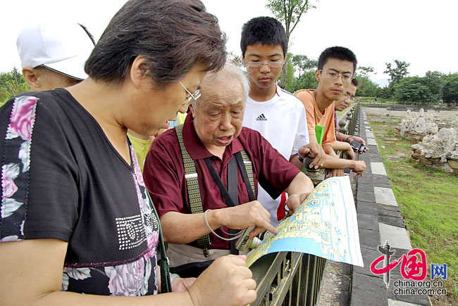圆明园学会资深会员、77岁的李剑泉老人义务为游客讲述景点的历史 龙邦/摄影