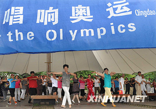7月30日，一群市民聚集在青岛音乐广场，在奥运歌曲旋律伴奏下载歌载舞。 