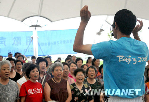  7月30日，在青岛音乐广场，一支市民合唱团在指导老师的指挥下演唱歌曲《和平奥运》。 