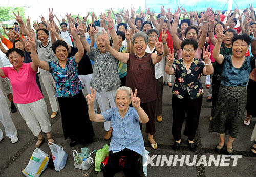 7月30日，在青岛音乐广场，一支市民合唱团在演唱完歌曲《和平奥运》后，同时做出了北京奥运会加油手势。
