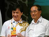 北京奥组委文化活动部部长赵东鸣（右）为成龙颁发奥运会志愿者注册卡。